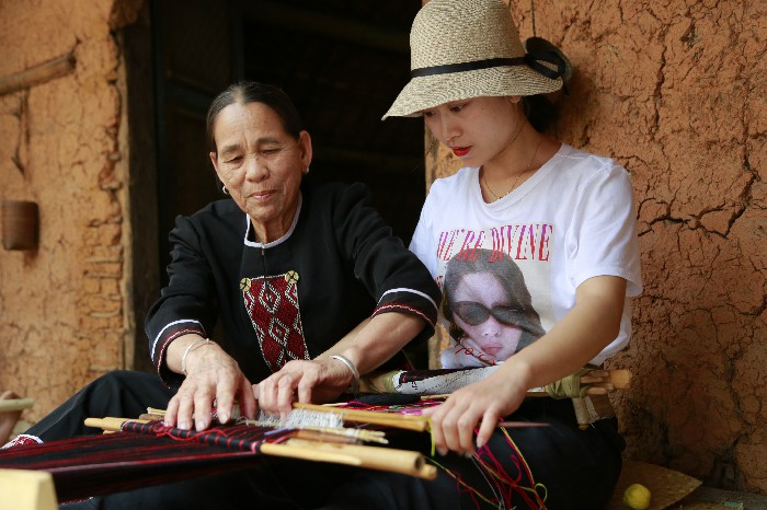 1、游客在和黎族文身阿婆學織黎錦